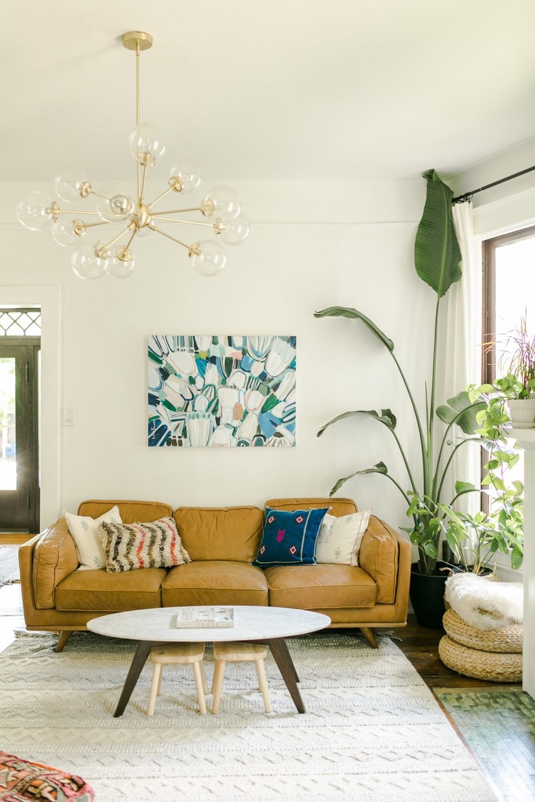 Living room with sputnik chandelier and camel leather couch.