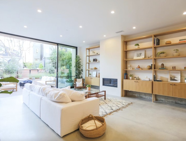 Open living room with built-in bookshelves and recessed can lights.