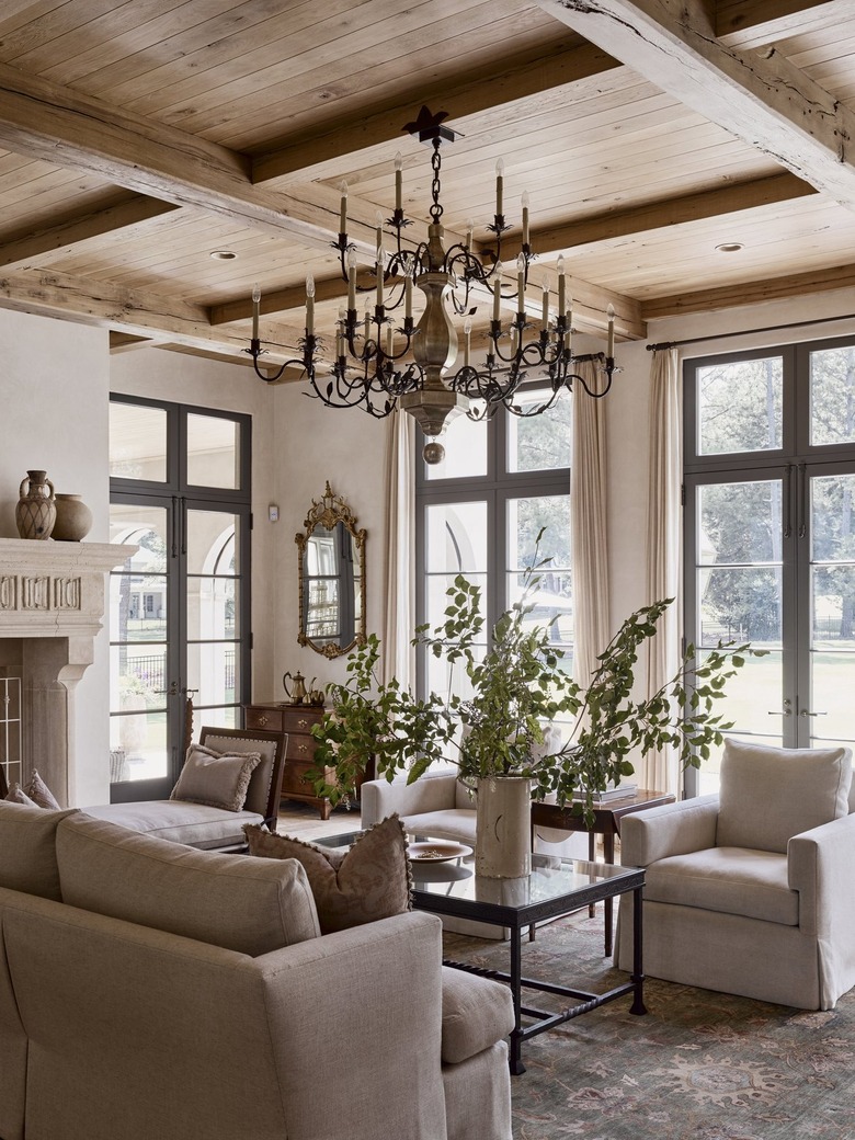 transitional french country living room with beige furniture and large chandelier