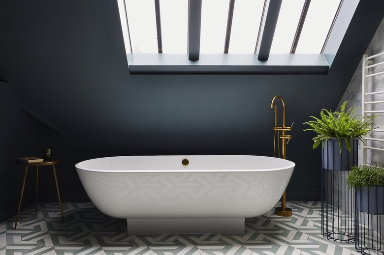 Industrial bathroom with black walls and a white tub.