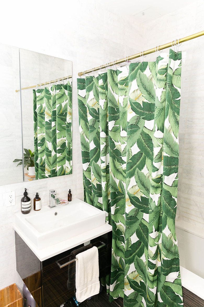white bathroom with tropical foliage shower curtain