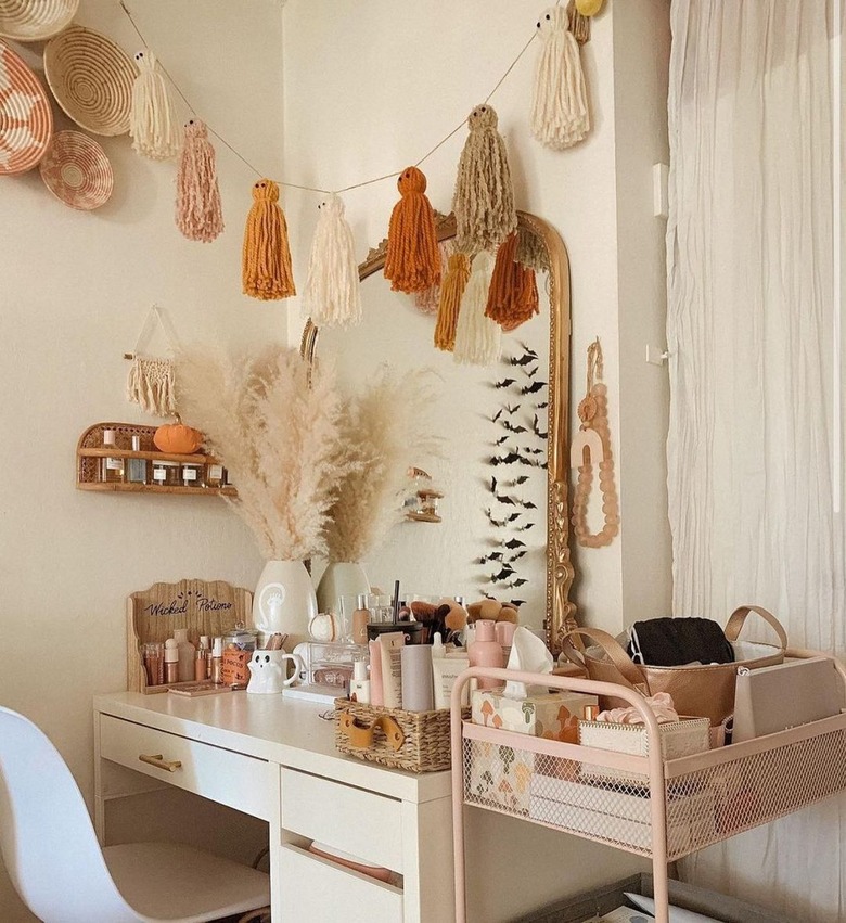 vanity table with ghost garland made of yarn tassels in sunset colors