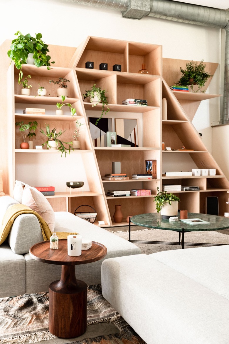 a living room with mid-century furniture dominated by irregularly shaped built in shelves