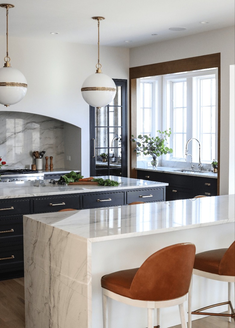open kitchen with marble countertops and oversized pendants
