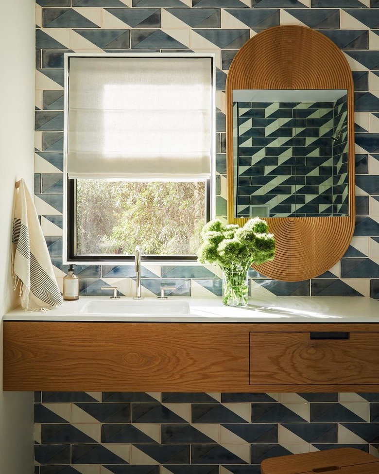 midcentury bathroom with blue and white geometric linear tile wall