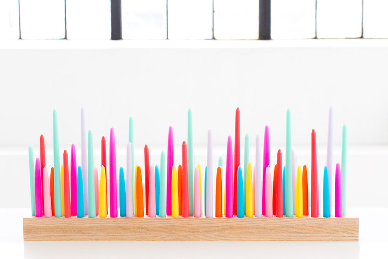 Colorful neon candles in a wooden holder