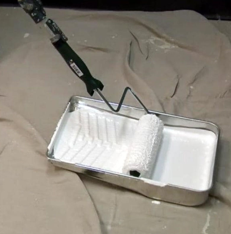 Paint roller and paint tray over a drop cloth