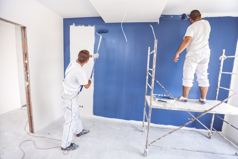 House painters beginning to paint a large blue wall