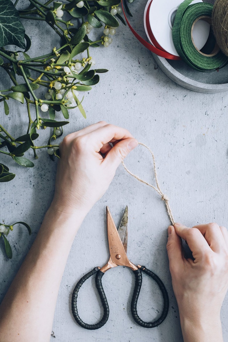 a crafter ties a piece of twine into a loop