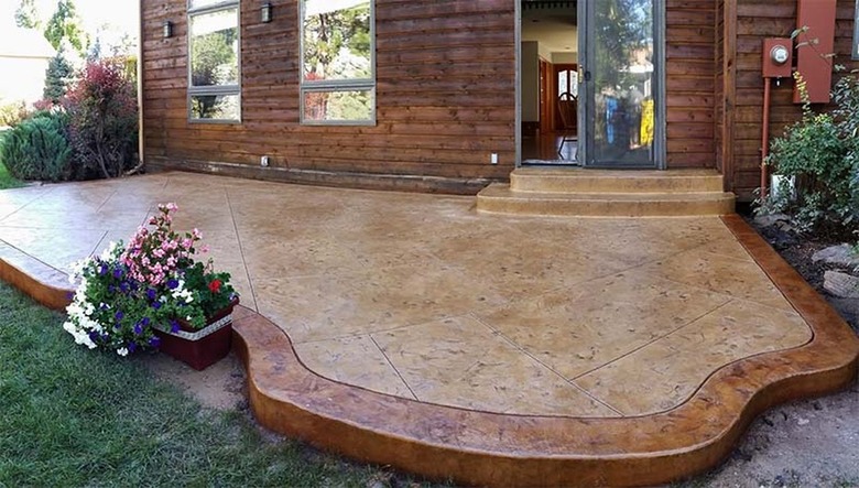 A brown concrete stamped patio with a bronze borer