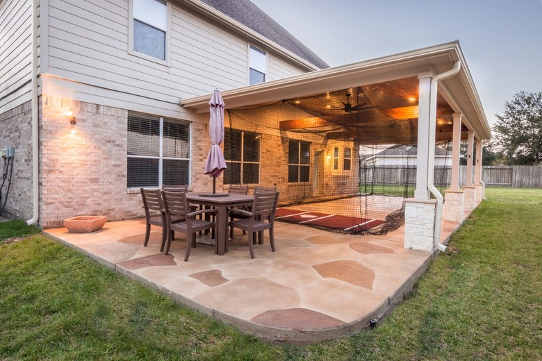 A multi-shade stamped concrete patio features a rounded corner