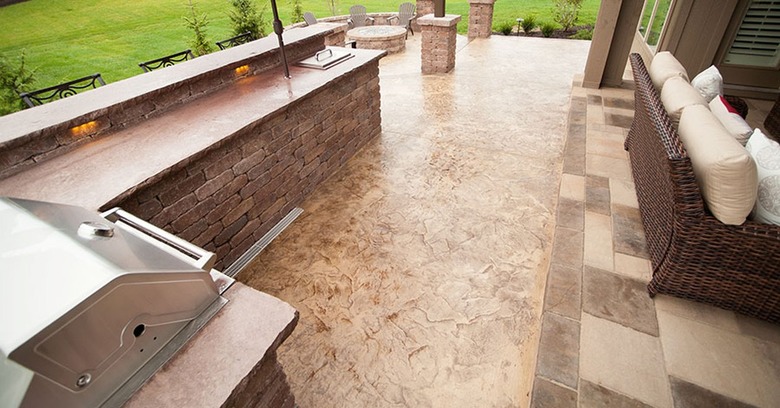 An outdoor kitchen with a brown stamped concrete floor