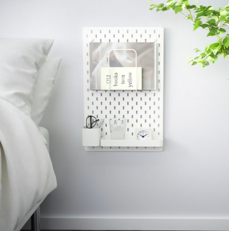 bed with pegboard on the wall nearby