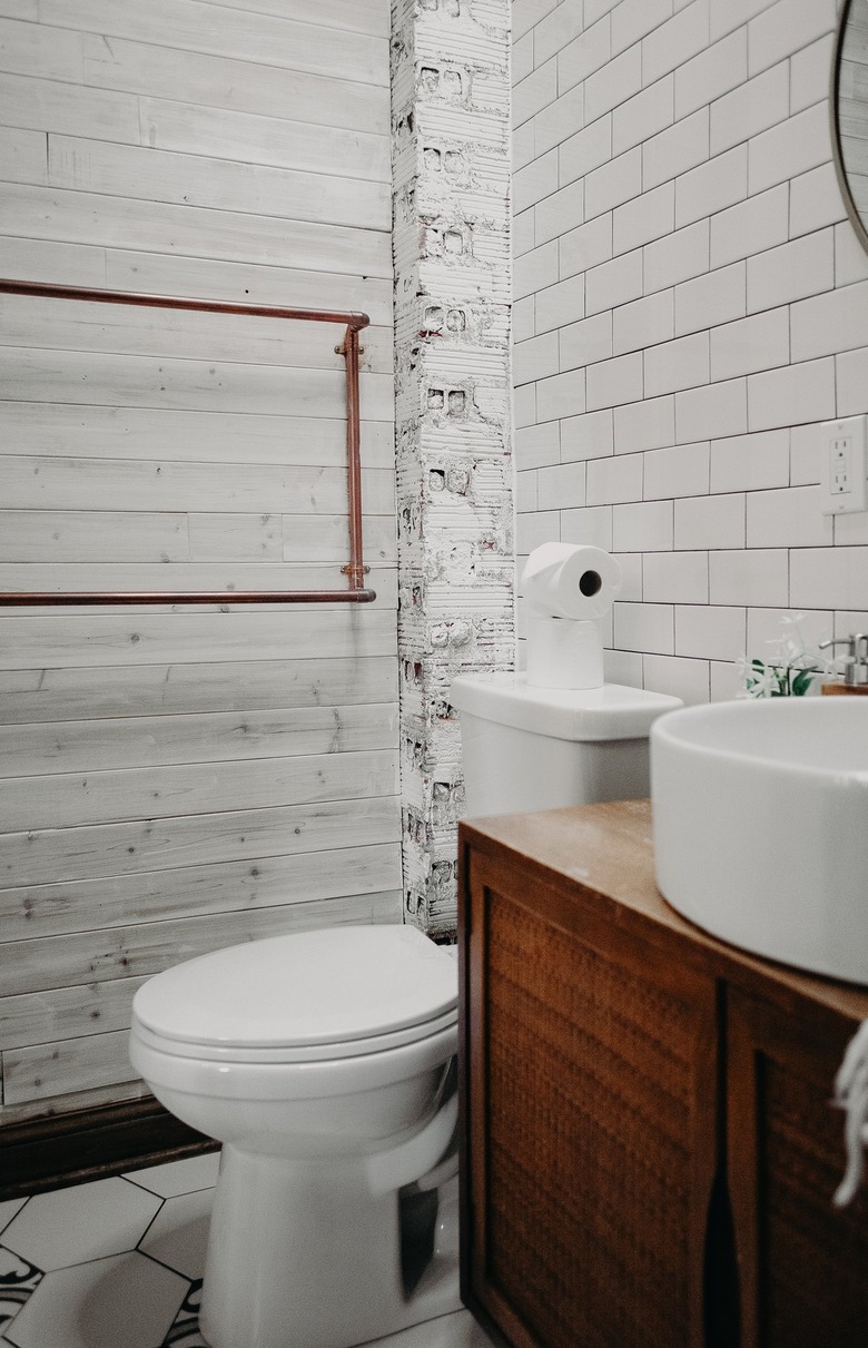 A small bathroom with a vessel sink on top of a wooden cabinet