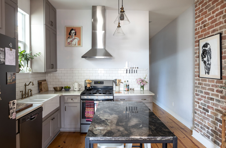 rustic kitchen with brick wall and gray cabinets