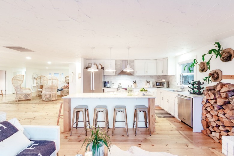 a large kitchen with an island flanked by metal stools