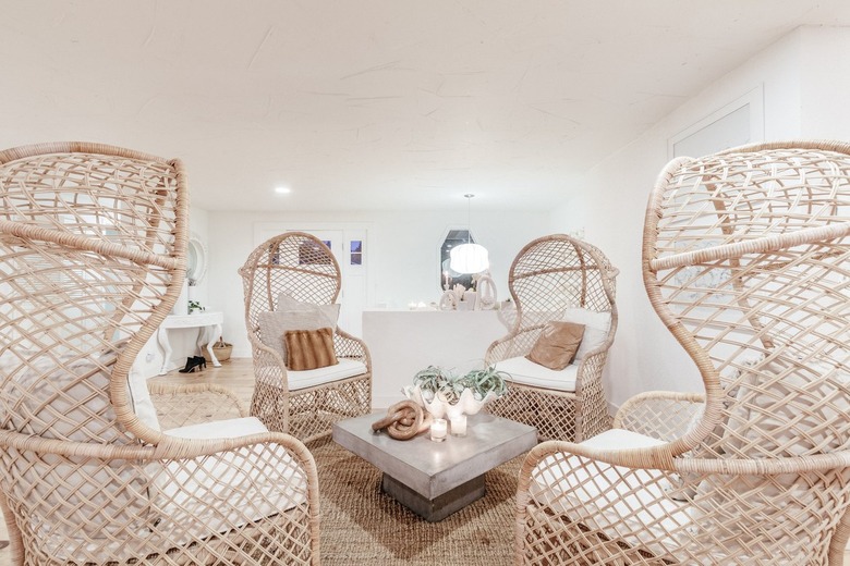 four high-backed wicker chairs around a square concrete coffee table