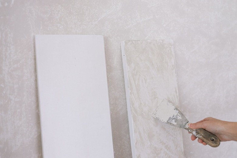 Applying Roman Clay to primed shelves with putty knife