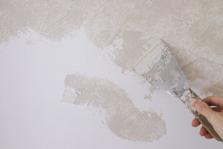 Applying Roman Clay to wall with putty knife