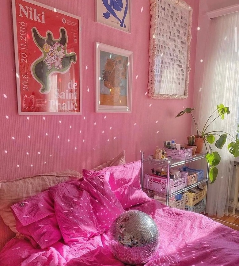 pink bedroom with disco ball on bed