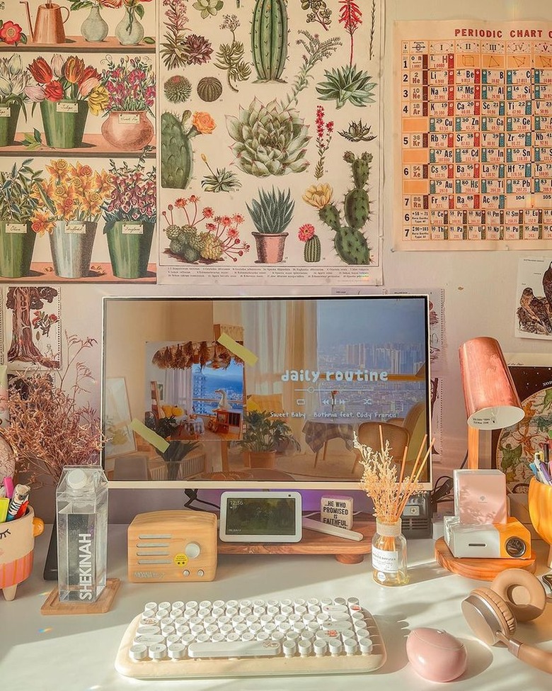 desk with botanical posters hung above it