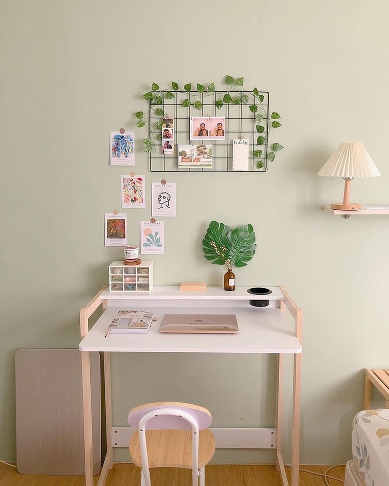 desk with wire memo board hanging above it and faux vines strung through the wires