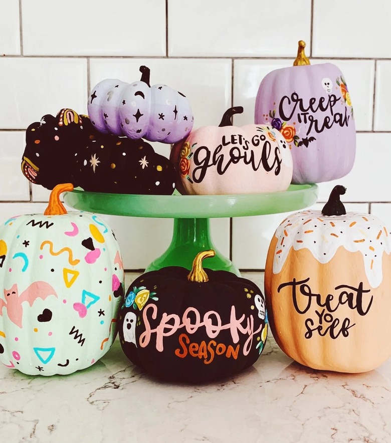 A set of seven painted pumpkins in different shapes and colors. Some have stars