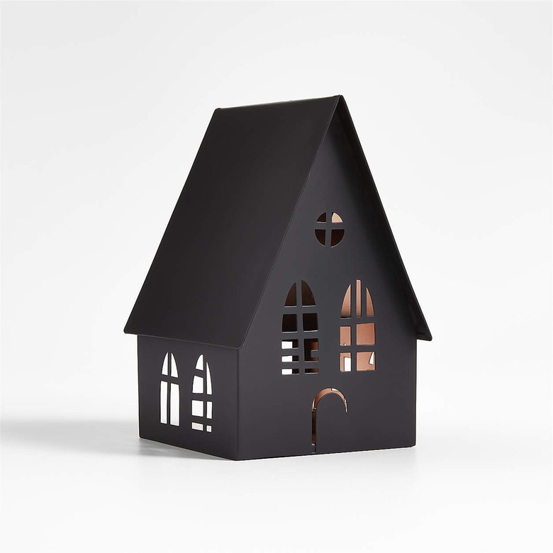 A black metal house with cut-out windows and a door.