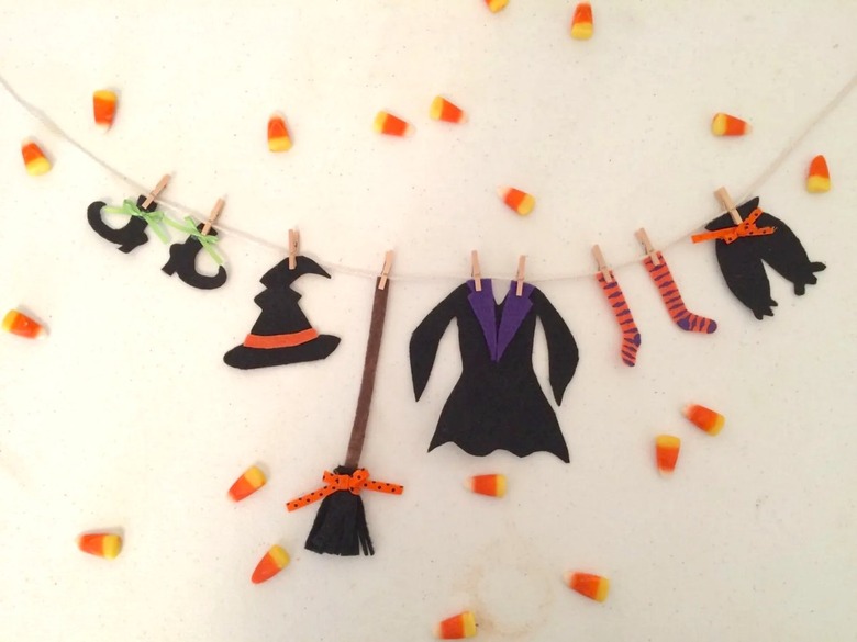 A yarn clothesline with cut-out witch clothes like pointy boots