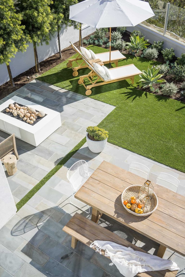 Clean and minimal outdoor space with lounge chairs and picnic bench