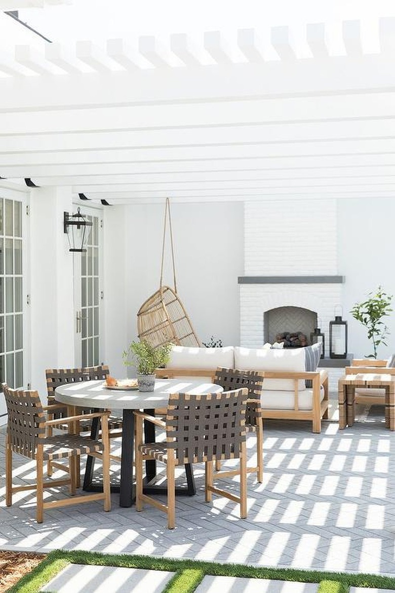 Clean and simple outdoor dining space with hanging lounge chair