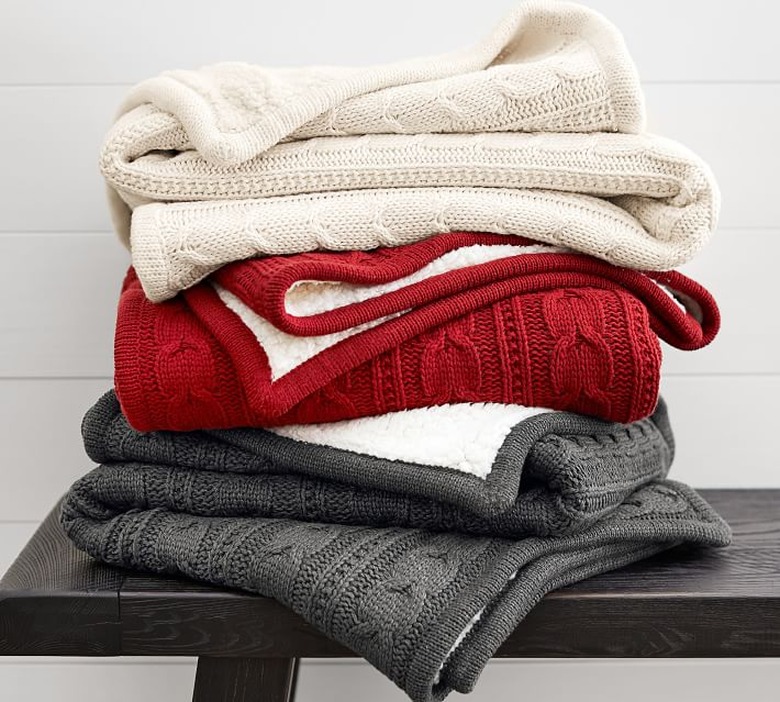 stacked cable knit blankets on table