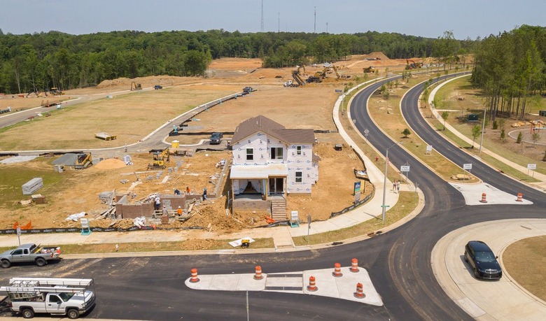 overhead view of land with house under construction and car nearby