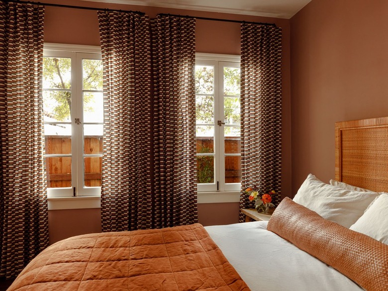 guest room with brown walls and wood headboard