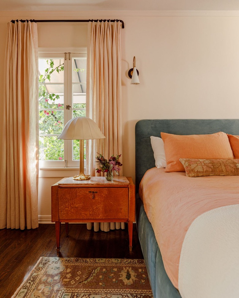primary bedroom with vintage furniture and teal bed frame