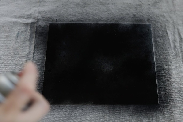 Spraying glass with black spray paint