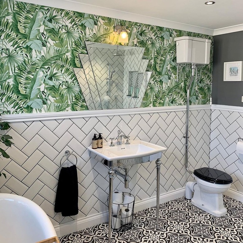 A twenties inspired bathroom with bold print wallpaper and geometric vintage mirror