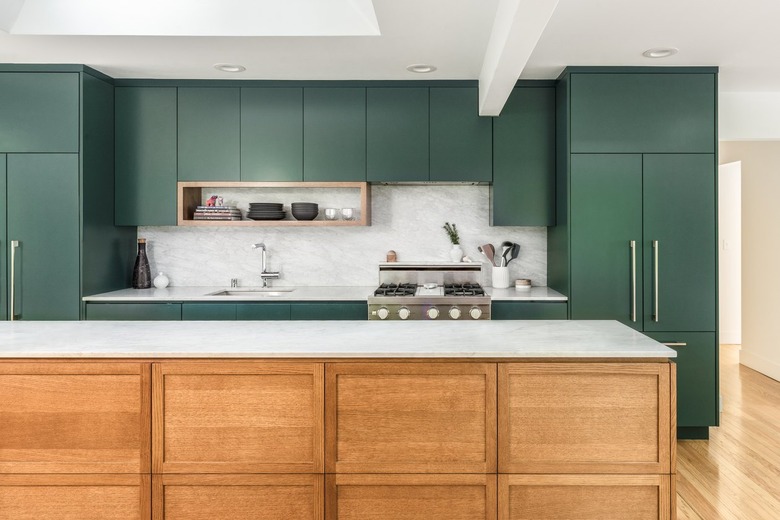 The kitchen's green cabinets are balanced with a warm wood island.