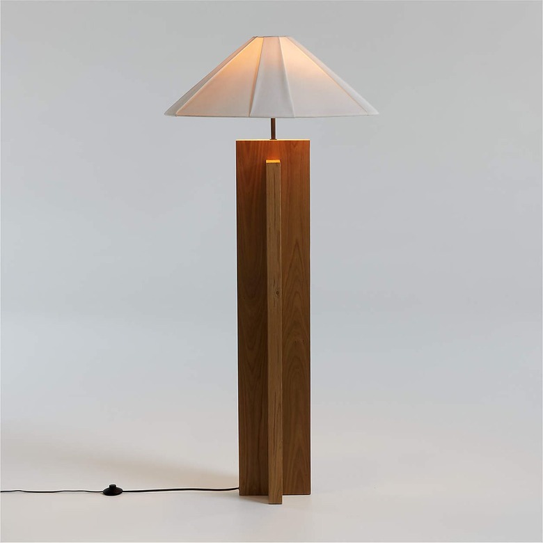 Lamp with a wooden base and a white shade in front of a white background