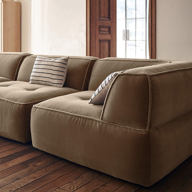 Pecan-colored three-piece sofa with striped pillows on a hardwood floor.