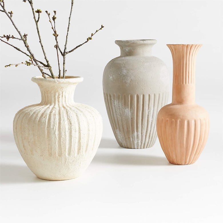 Three terracotta vases in different shapes: one white