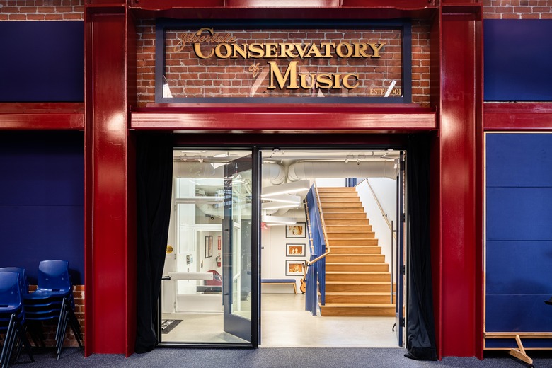 Glass door entrance with blue walls and staircase in the distance