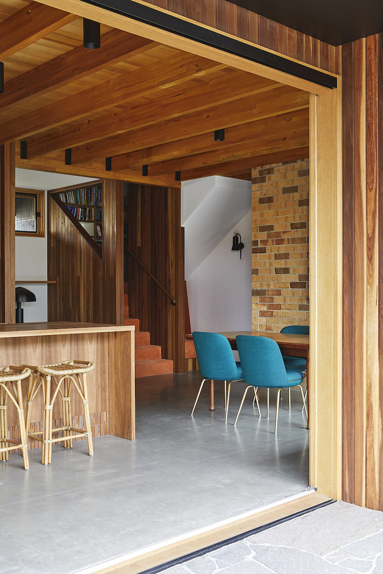 wood basement furniture with bar, rattan bar stools, and blue dining chairs