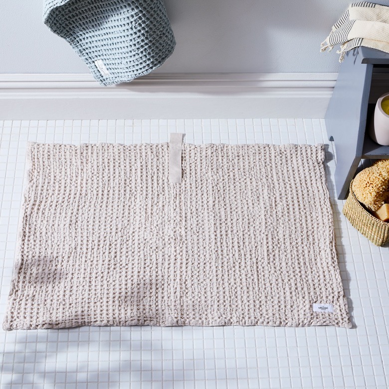 Food52 waffle bath mat on a white mosaic tile floor