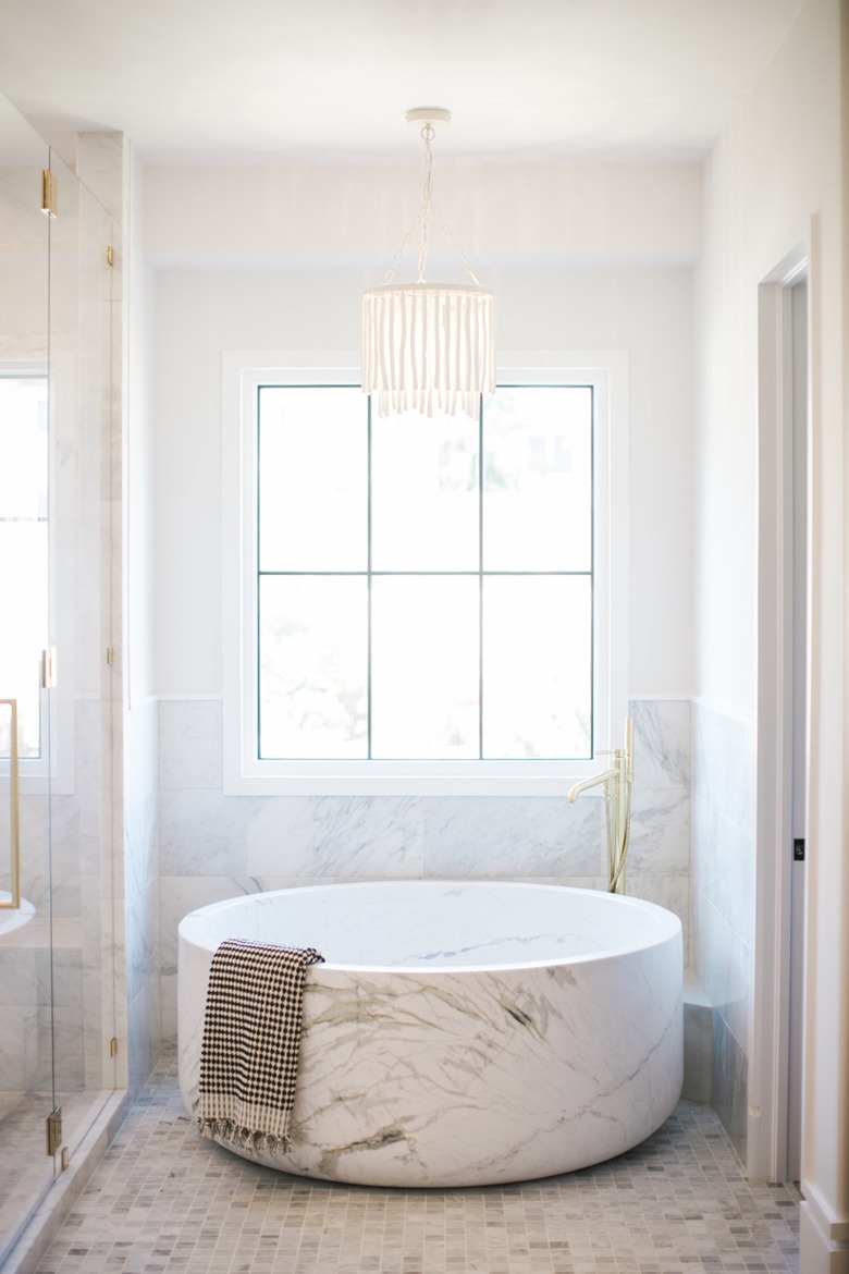 bathroom chandelier lighting idea with wood beaded fixture hanging over marble tub