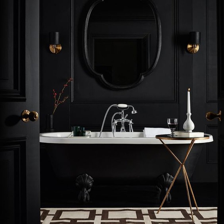 black bathroom walls with black clawfoot tub and black door