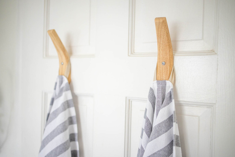 Two wooden towel hooks hung on door