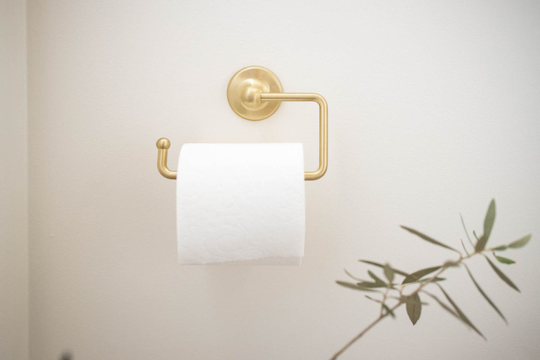 Brass toilet paper holder in bathroom