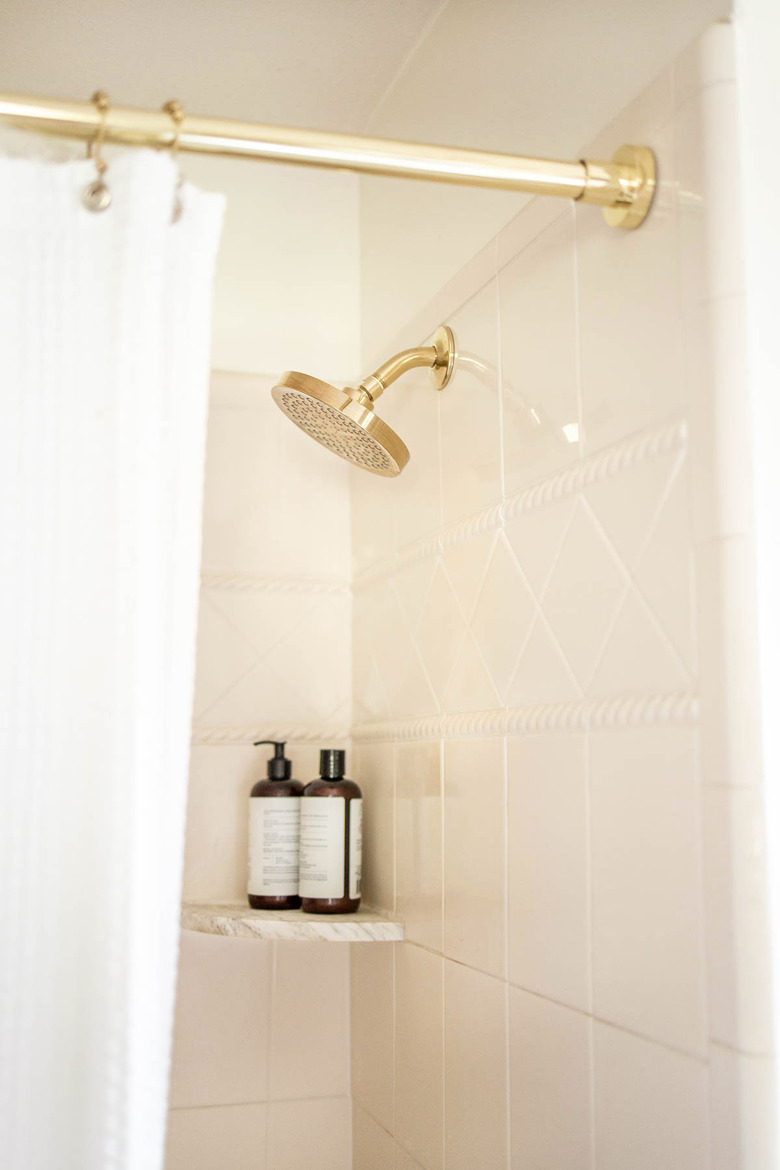Brass shower head and shower rod in bathroom