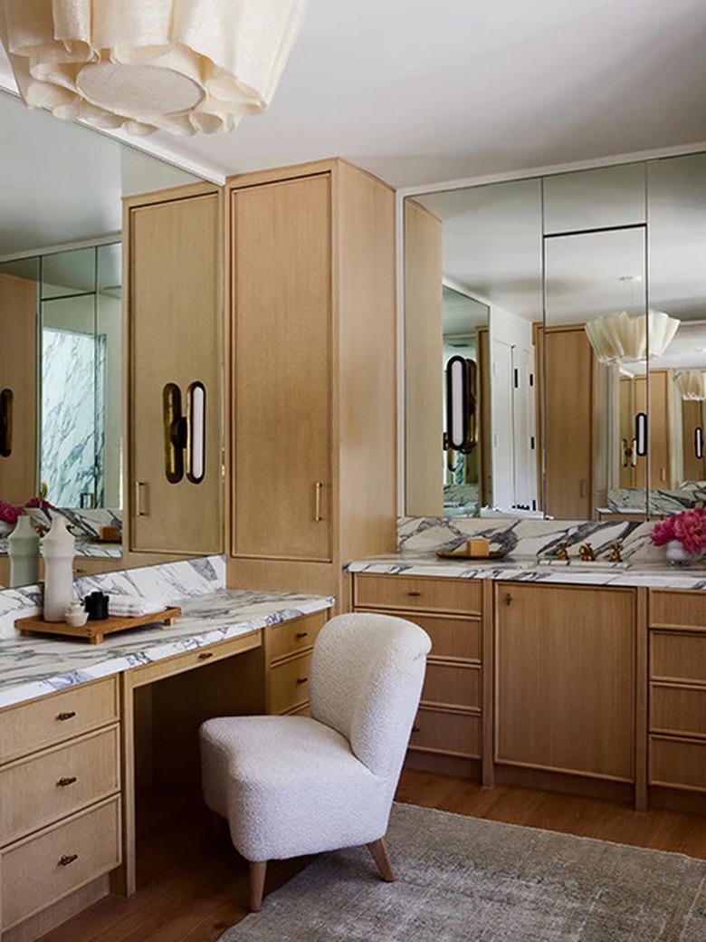 bathroom makeup vanity with bouclé chair and marble countertop